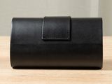 a black leather case sitting on top of a wooden table