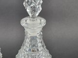 pair of clear glass decanters on a black background