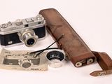 a leather case with a camera and a pair of binoculars