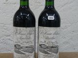 deux bouteilles de vin rouge posées sur une table en bois