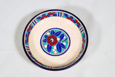 une assiette bleue et blanche ornée d'une fleur rouge