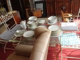 a glass table with plates and bowls on it in a living room