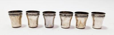 six shot glasses are lined up in a row on a white surface