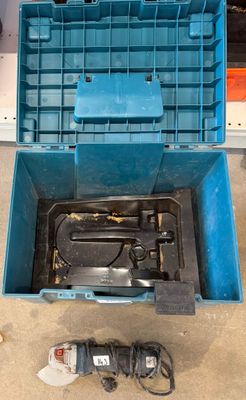 une boîte à outils bleue avec des outils sur le sol