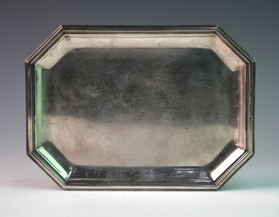 an antique silver plate with a green glass in the center