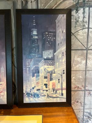 deux photos encadrées représentant un paysage urbain, posées sur une table