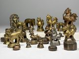 de nombreuses figurines en laiton posées sur une surface blanche