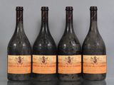 four bottles of wine are lined up on a table