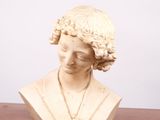 un buste de femme assise sur une table en bois