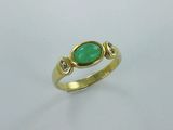 une bague en or sertie d'une pierre verte et de deux diamants