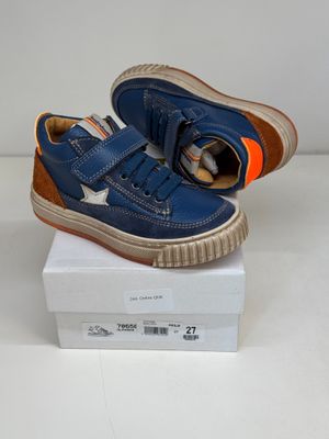 blue leather sneakers with orange soles on top of a white box