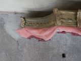 a pink cloth on the floor next to an old clock