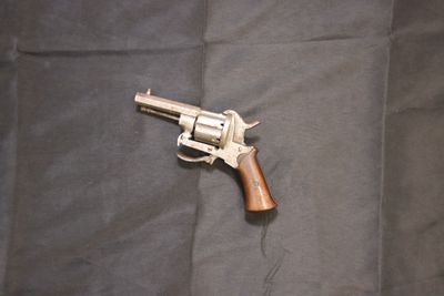 un pistolet posé sur une couverture, par terre