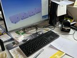 un bureau sur lequel se trouvent un ordinateur, un clavier, une souris et des papiers