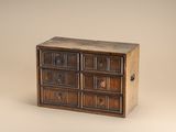 une petite commode en bois sur fond beige