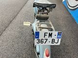 a blue moped parked on the side of the road