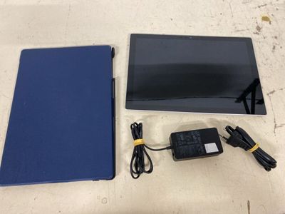 an image of a tablet computer sitting on top of a table next to a charger
