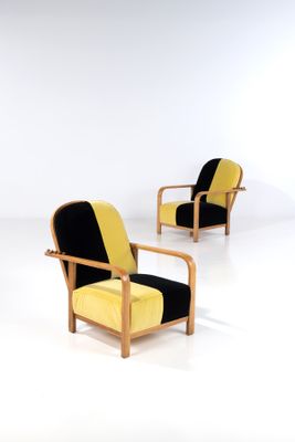 three yellow and black chairs in a white room with a white wall