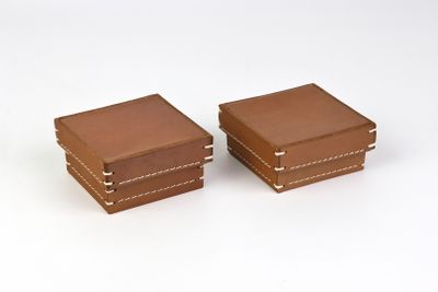 une paire de boîtes en cuir marron sur fond blanc