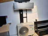 une photo d'une pièce avec un bureau et un climatiseur