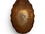 a gold plate hanging on the wall with a spoon