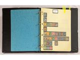 un classeur noir avec une couverture bleue et des timbres dessus