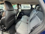 the back seats of a blue car are empty in a parking lot