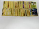 a pile of pokemon cards sitting on top of a white table