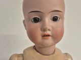 a small doll that is sitting on a white surface