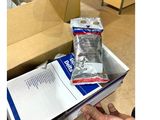 someone is holding a package of condoms in a box on the floor