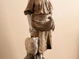 a statue of a woman with a sheep on a table
