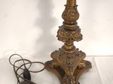 an antique brass table lamp with a cord plugged to it