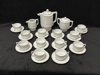 de nombreuses tasses et soucoupes posées sur une table, sur fond noir