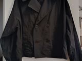 black jacket hanging on a white wall in a room