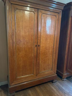 une photo d'une armoire en bois posée sur un parquet en bois massif