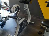 un vélo d'appartement dans une salle de sport aux murs jaunes