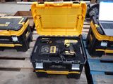 une caisse à outils jaune contenant un ordinateur portable, posée sur une palette