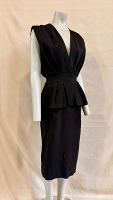 a mannequin dressed dress with a pepilly top on a mannequin base