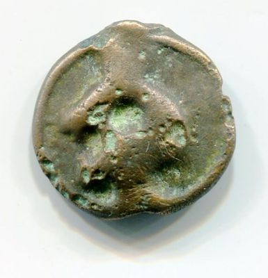 une vieille pièce de monnaie sur laquelle est représenté un visage, posée sur une surface blanche