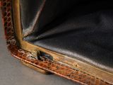 a close up of a black leather case with a gold handle