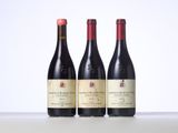 three bottles of red wine are lined up on a table