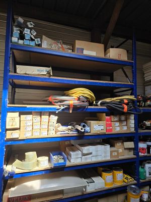 a blue shelving with lots of boxes and supplies on it