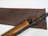 an old shotgun with a leather case and a wooden handle