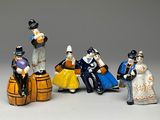 cinq figurines représentant des personnes assises sur un tonneau