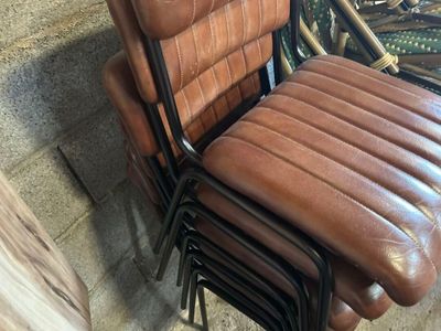 un fauteuil en cuir marron posé à côté d'une pile de vélos
