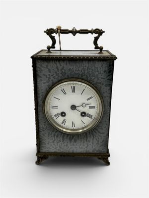 a small metal clock with roman numerals on the face