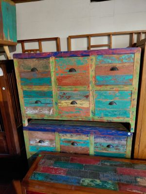 a wooden dresser with many drawers and a bench