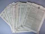 several newspapers are stacked on top of each other on a table