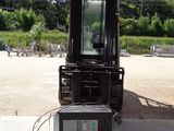 a forklift truck parked in a lot with a lot of trees in the background