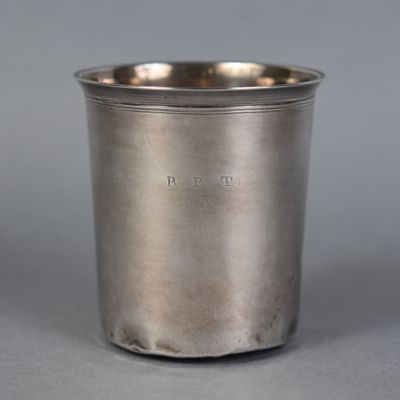 a close up of a silver cup on a gray surface
